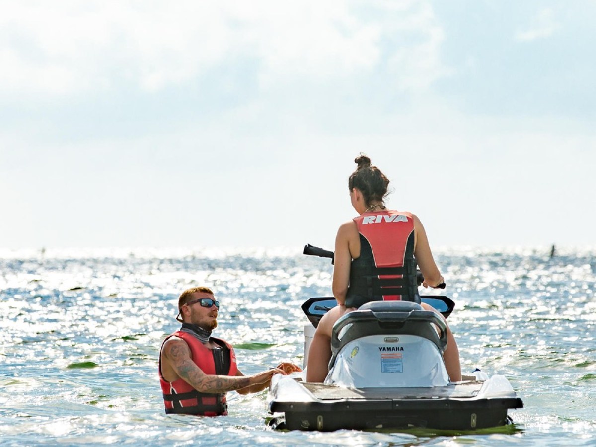 a group of people riding on the back of a boat in the water