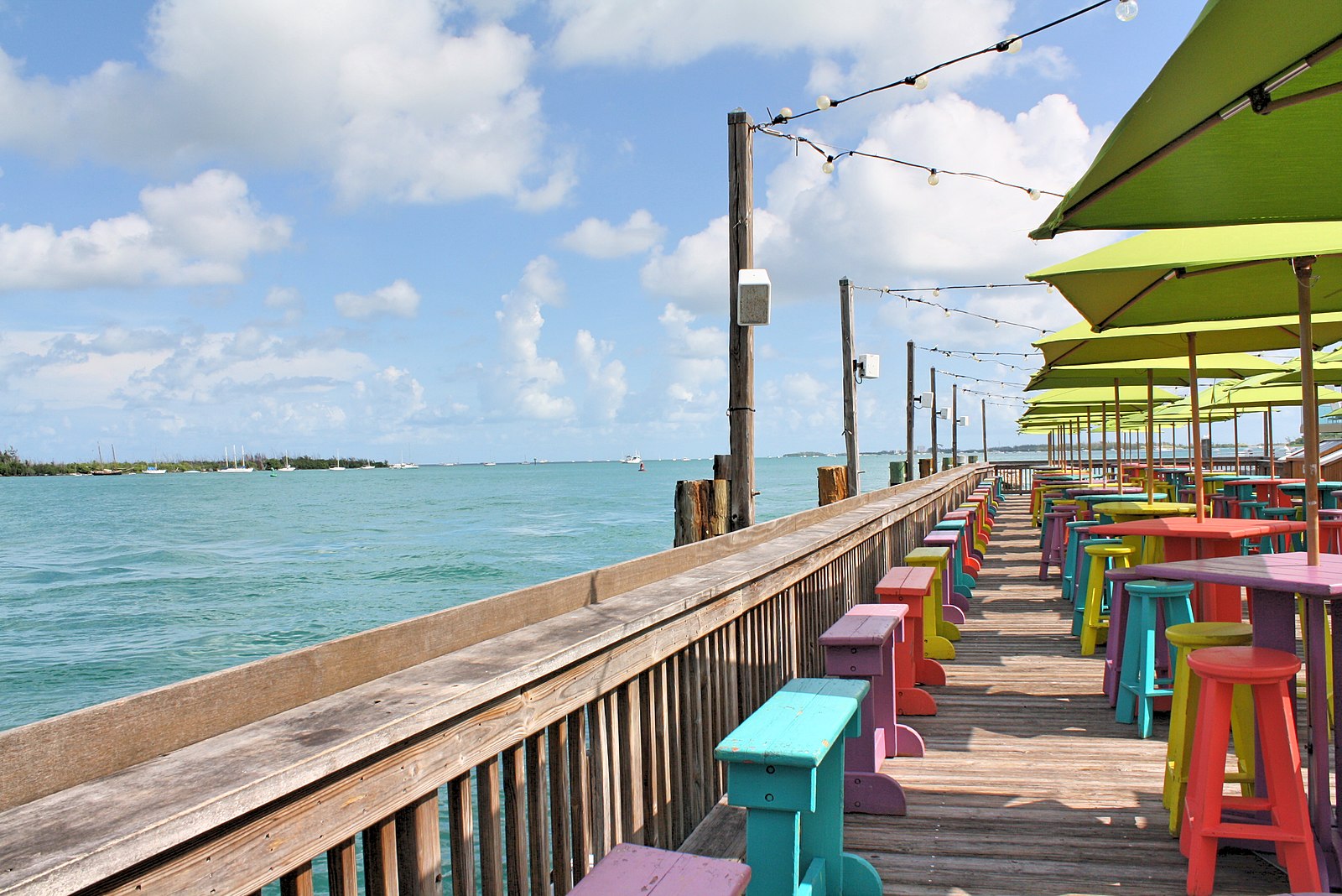 a row of wooden benches sitting next to a body of water