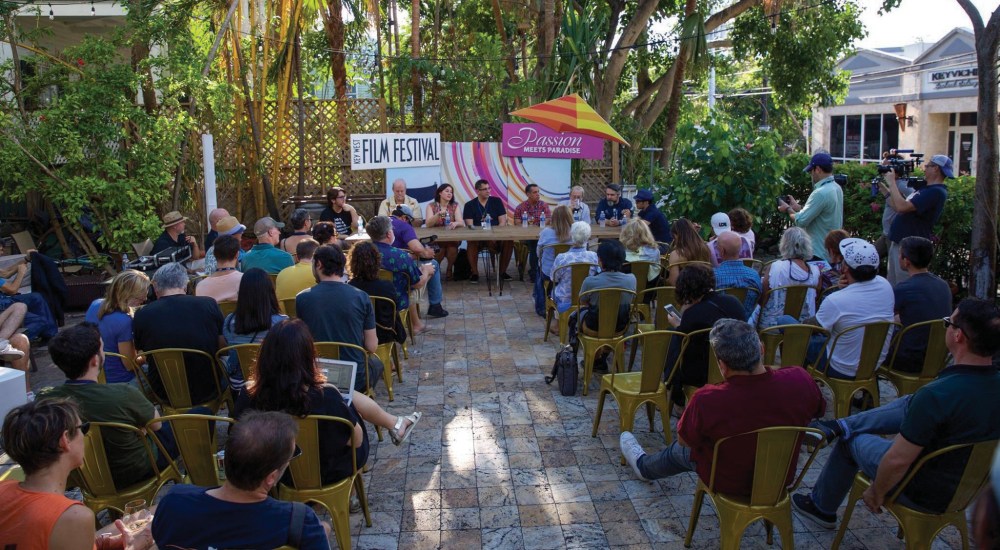 a group of people sitting at a table in front of a crowd