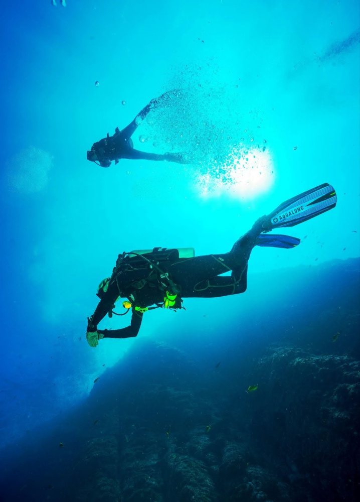 a person flying through the air while swimming in a body of water